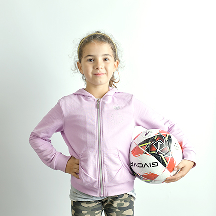 Immagine di una bambina in piedi con un pallone realizzata in studio da Ferruccio Munzittu