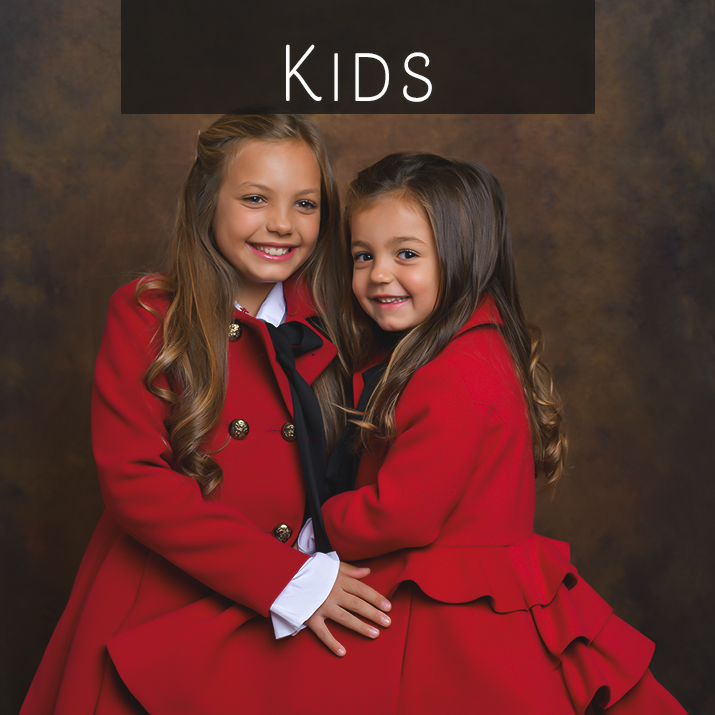 Foto di due bambine, sorelle, con cappotto rosso realizzata in studio da Ferruccio Munzittu