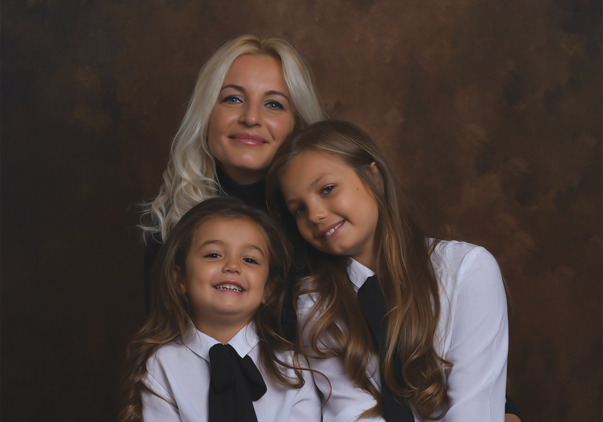 Immagine di una mamma con bambine sorridenti, scattata in studio da Ferruccio Munzittu