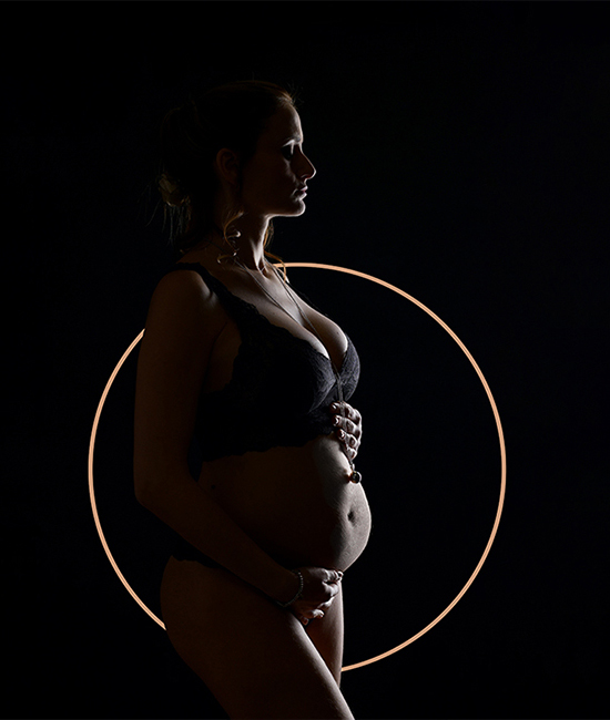 Foto artistica di donna incinta con il pancione, in low-key, ripresa di profilo, scattata in studio da Ferruccio Munzittu