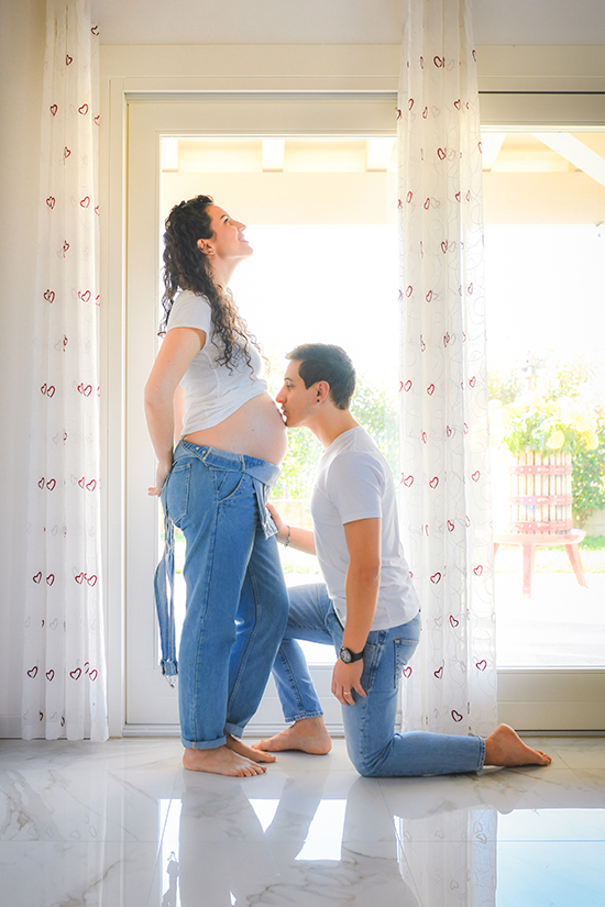 Foto di donna incinta davanti alla finestra con il futuro papà che bacia il pancione, foto scattata da Ferruccio Munzittu