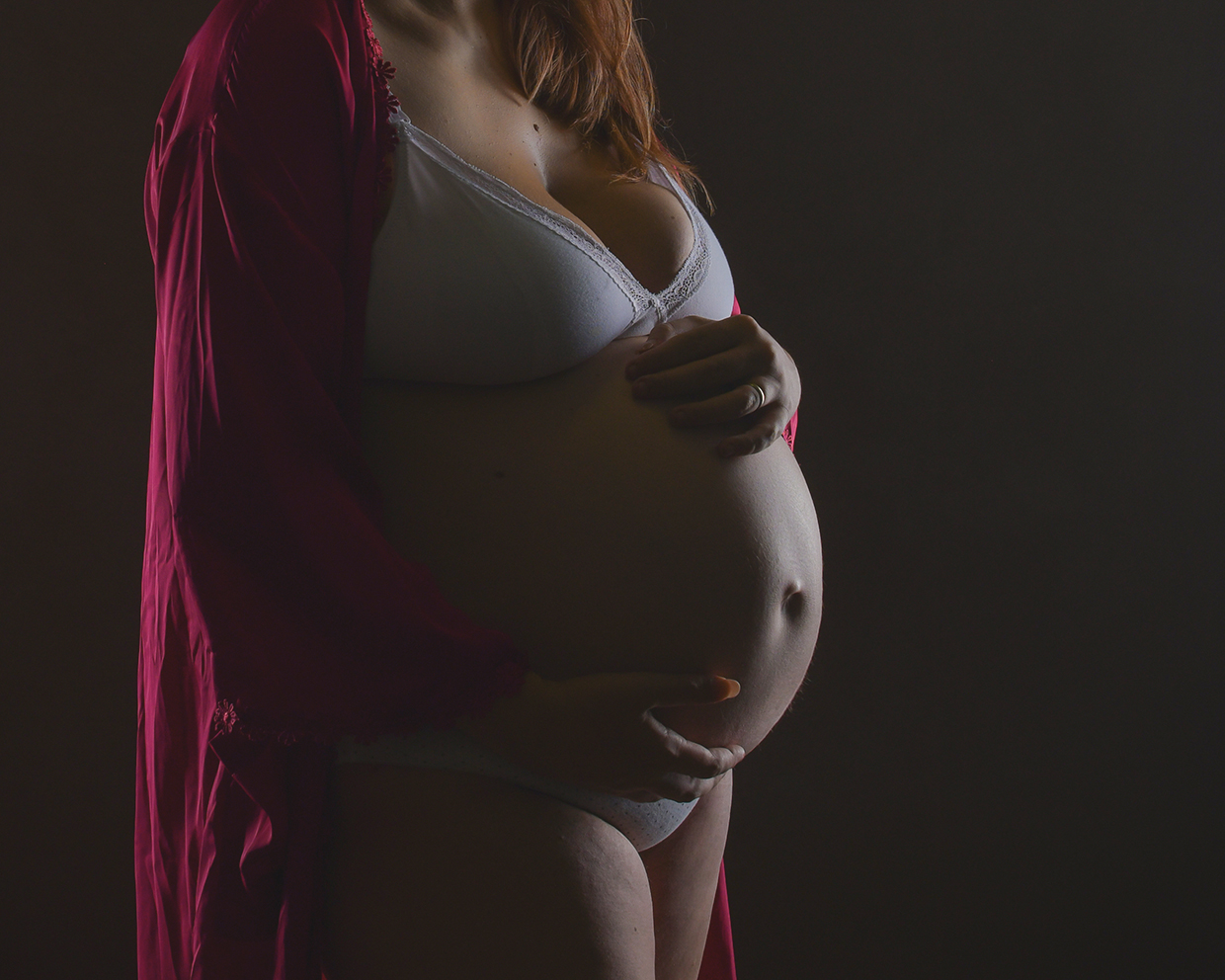 Foto artistica di donna incinta con il pancione con illuminazione laterale, scattata in studio da Ferruccio Munzittu