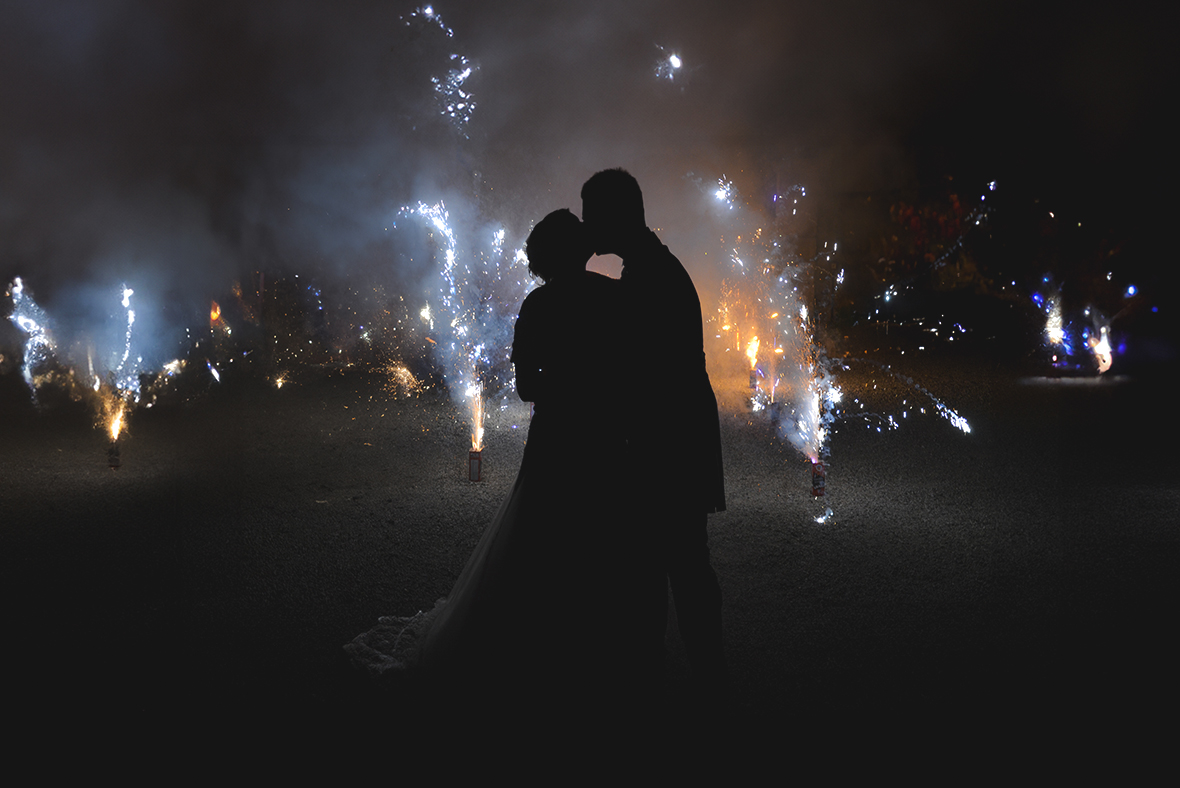 Immagine dei due novelli sposi che si baciano in mezzo ai fuochi d'artificio, foto di Ferruccio Munzittu